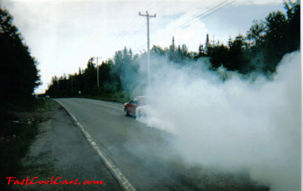 Red Ford Mustang GT doing burnout.