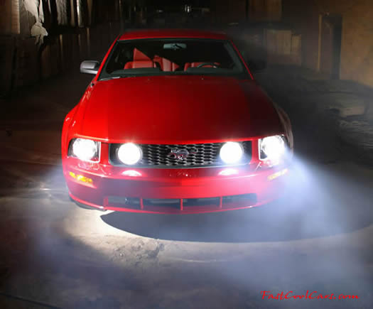 2005 Ford Mustang GT front view at night with headlights on
