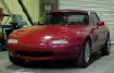 1990 Mazda Miata Roadster - Soft top, 5 speed, little red sports car.