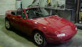 1990 Mazda Miata Roadster - Soft top, 5 speed, little red sports car.